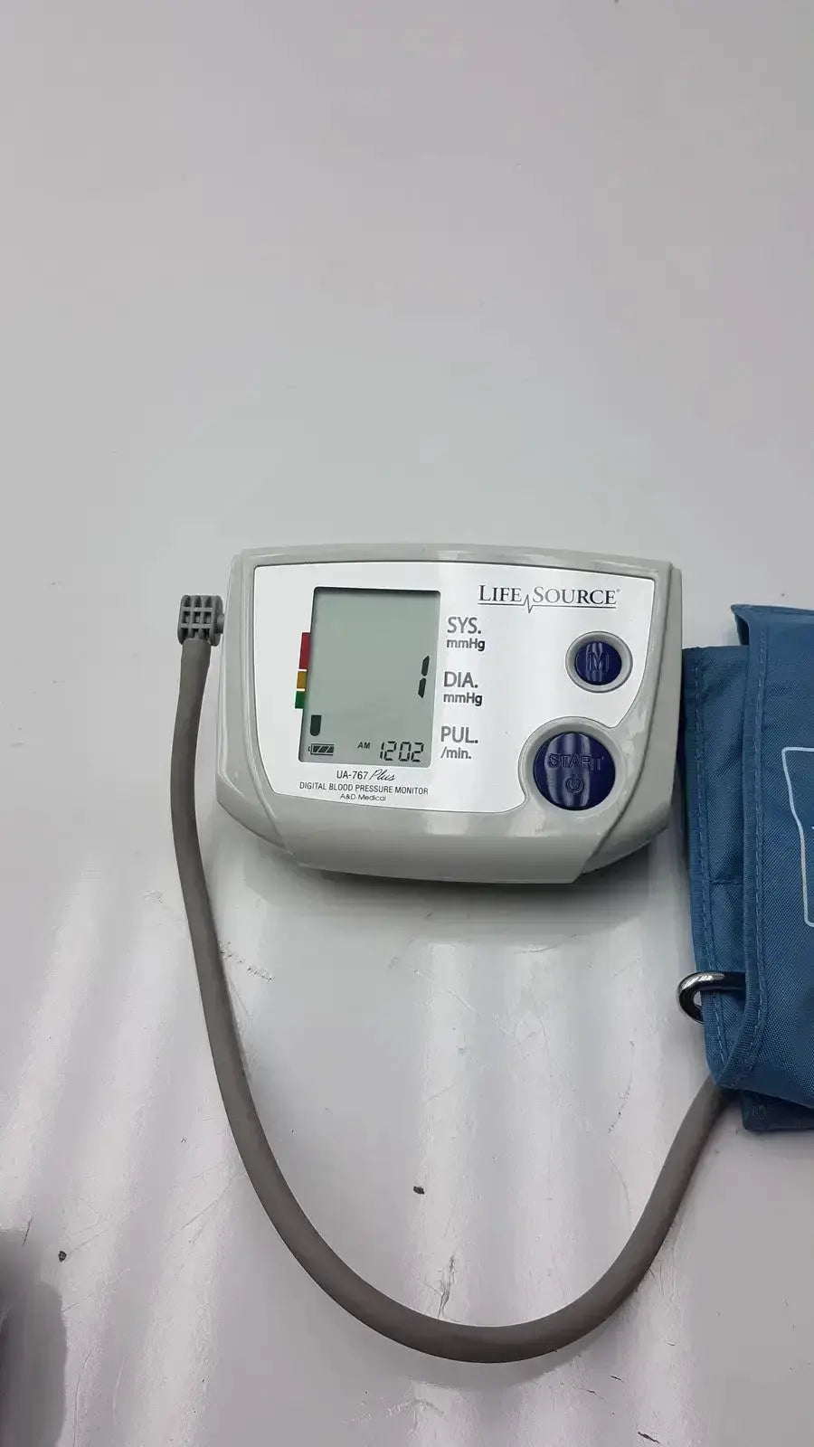 Life Source model UA-767 Plus digital blood pressure monitor with white casing, blue buttons, and blue inflatable cuff