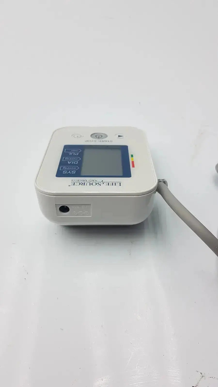 White plastic lifeSource a&d medical ua-651s-ac digital blood pressure monitor with blue display panel and gray tubing