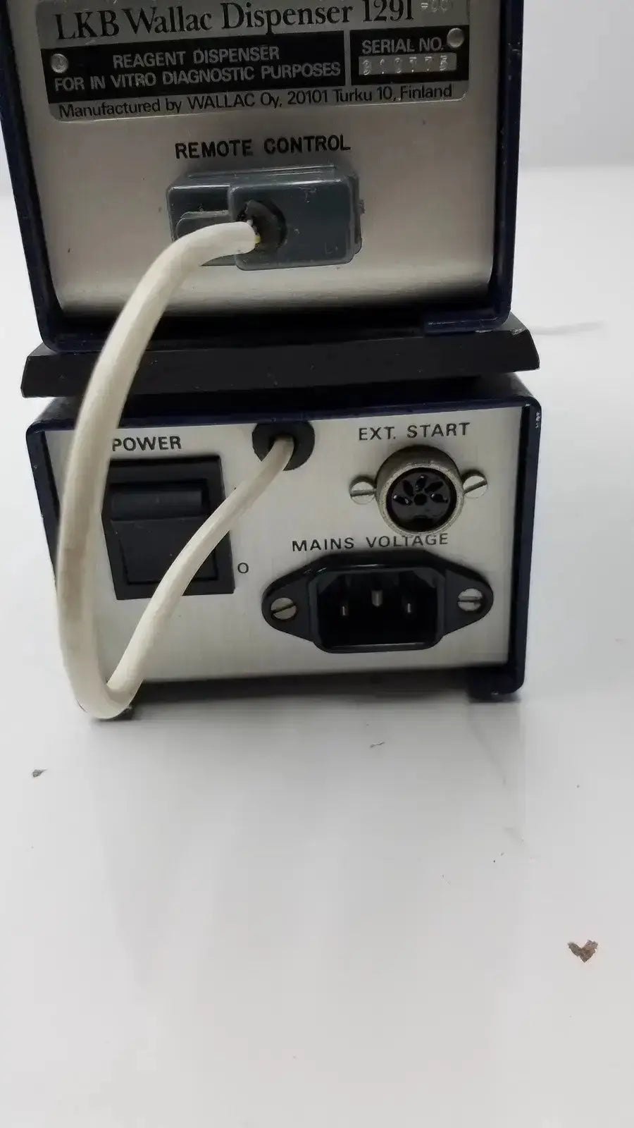 Black and silver lkb wallac 1291 reagent dispenser with white power cord connected to rear panel for in vitro diagnostic purposes