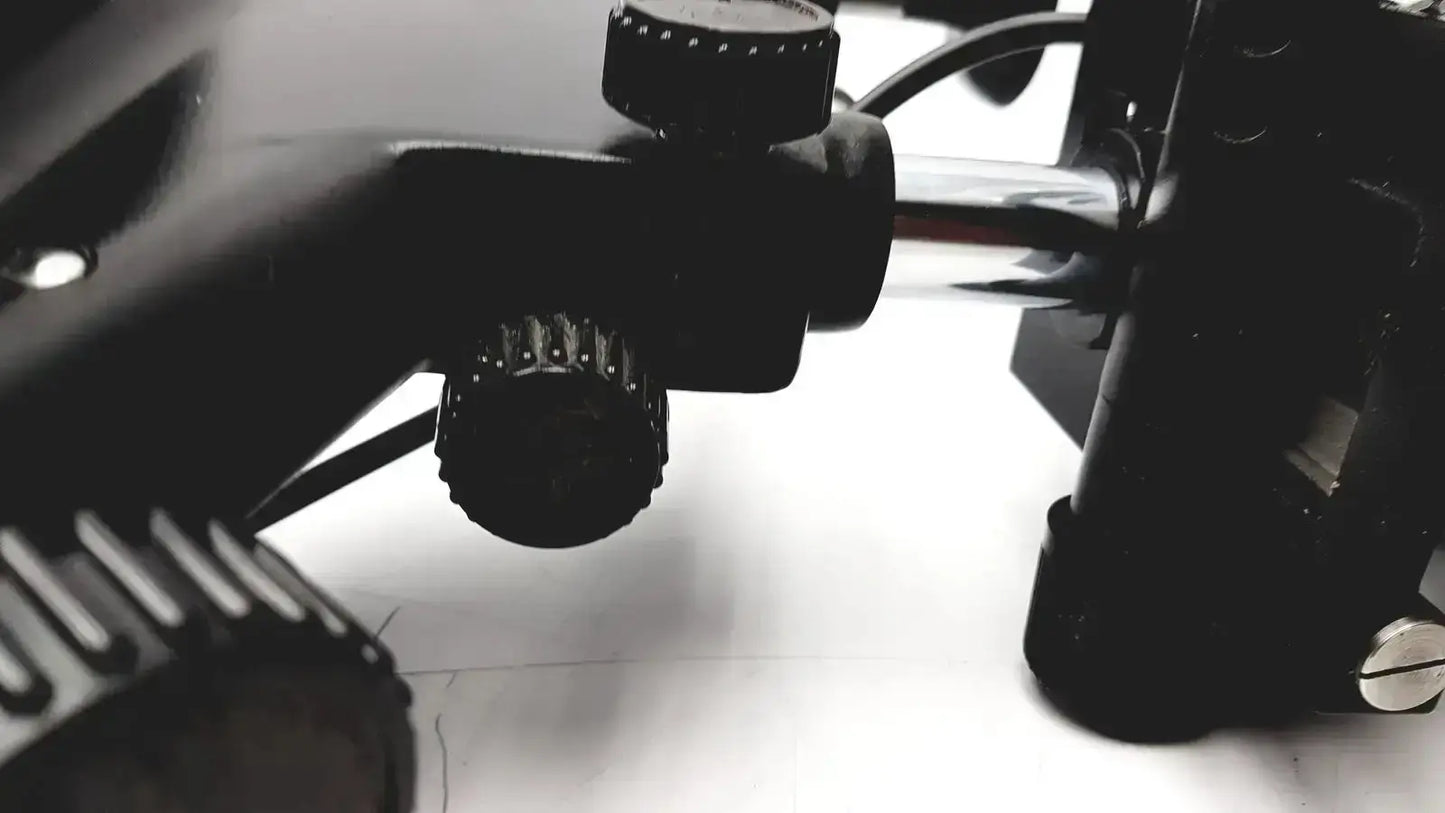 Black textured adjustment knobs on the back of lombart instrument keratometer model 12515 lens mount