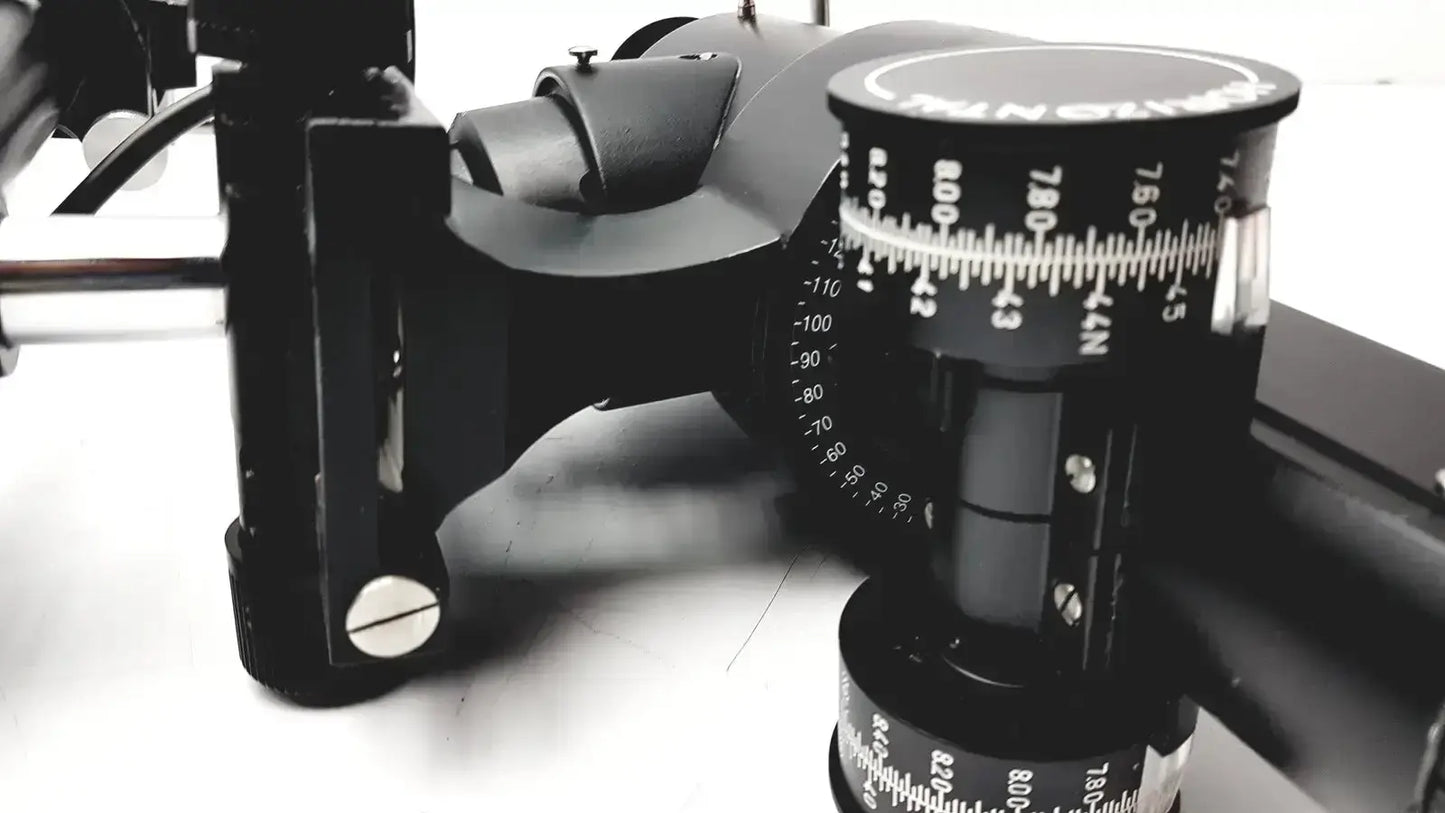 Black camera tripod head with adjustable tilt and pan scales on lombart instrument keratometer model 12515
