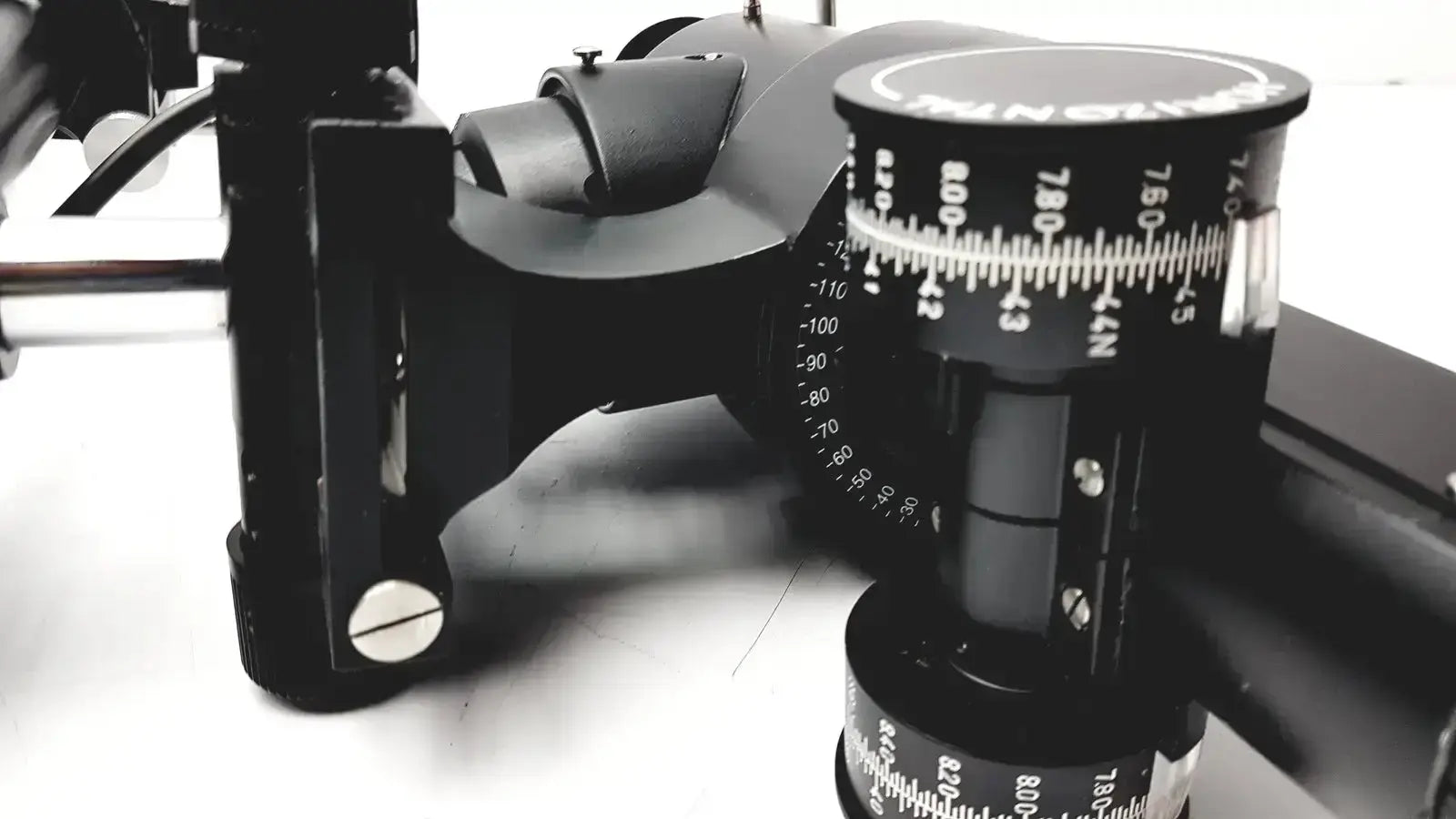 Black camera tripod head with adjustable tilt and pan scales on lombart instrument keratometer model 12515