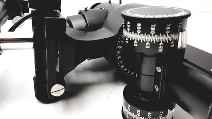 Black camera tripod head with adjustable tilt and pan scales on lombart instrument keratometer model 12515