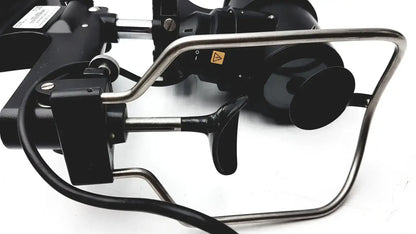 Black and silver industrial robotic arm with metallic joints and warning label on lombart instrument keratometer model 12515