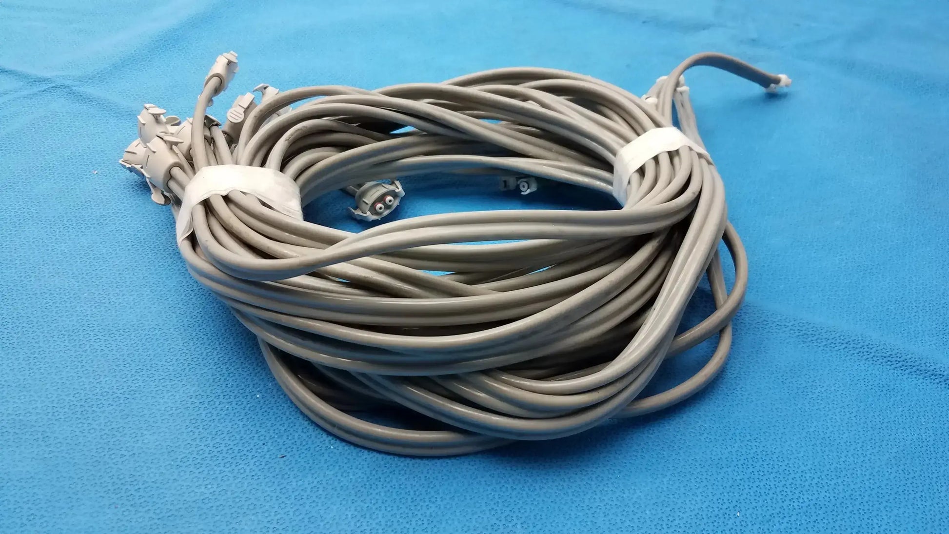 Coiled gray nibp air hose with multiple air hose fast connectors secured by white ties for double tube use