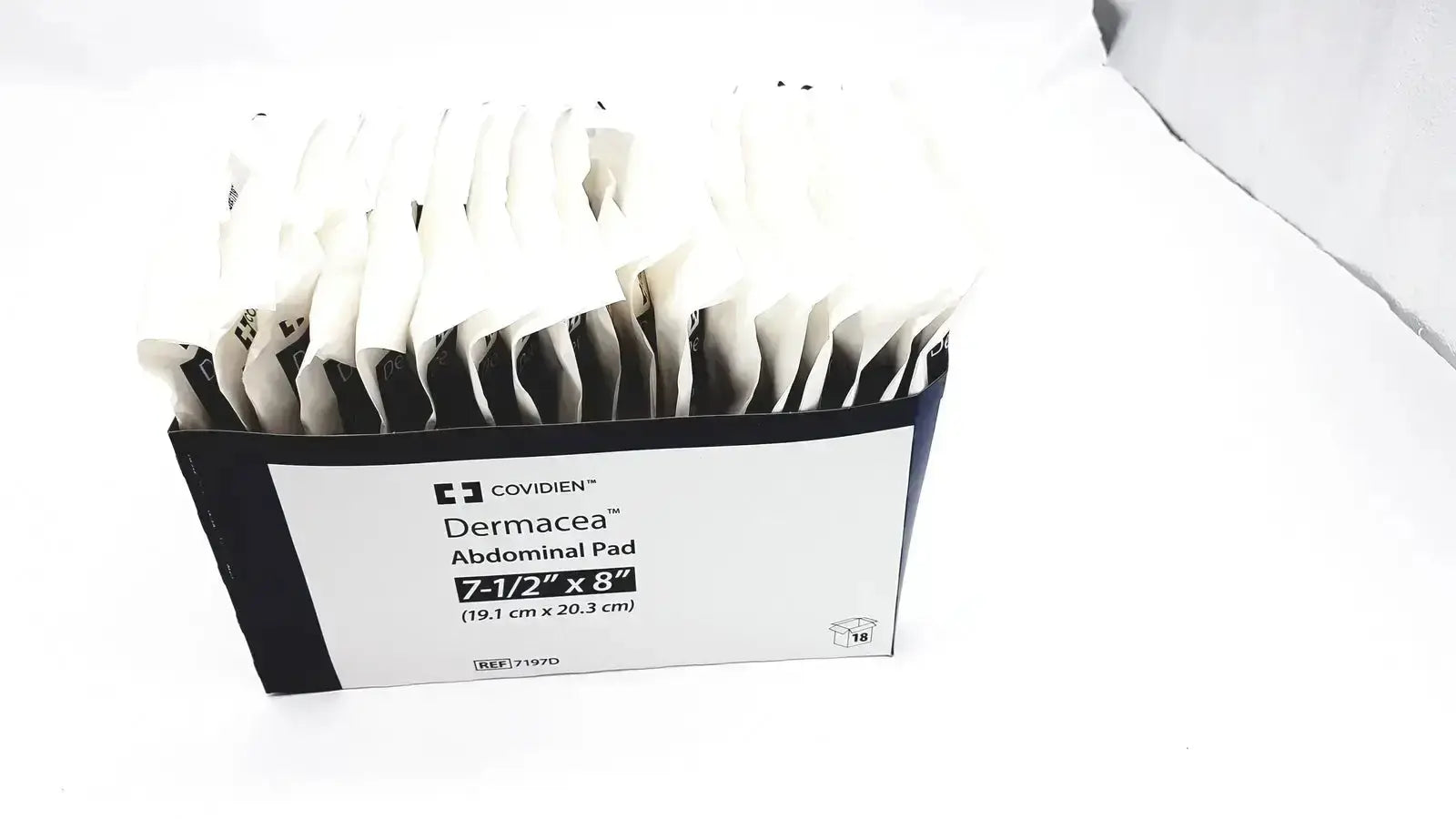 A box of 18 covidien dermacea abdominale pads 7 1/2x8 individually wrapped in black and white packets