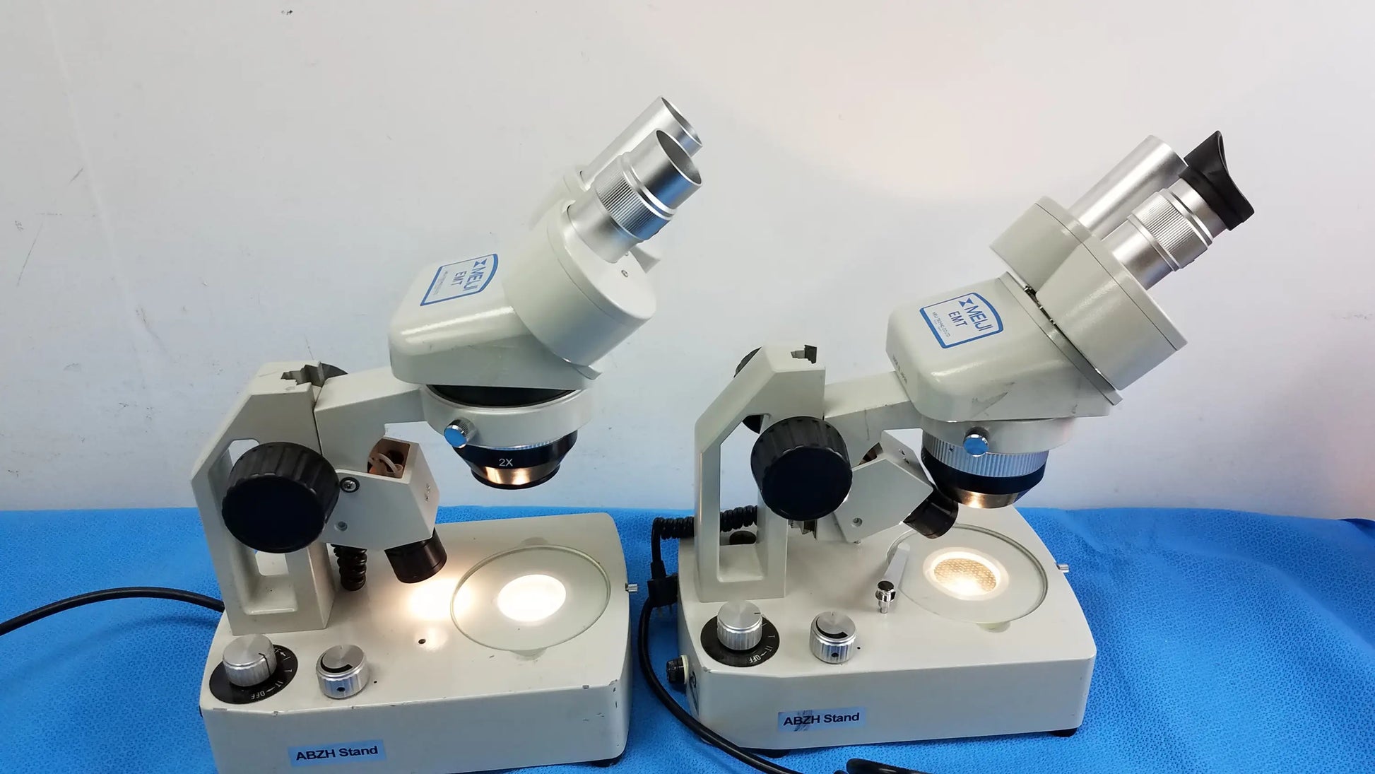 Lot of 2 beige meiji techno emt-1 stereo microscopes with silver eyepieces black knobs and built-in circular light medical equipment