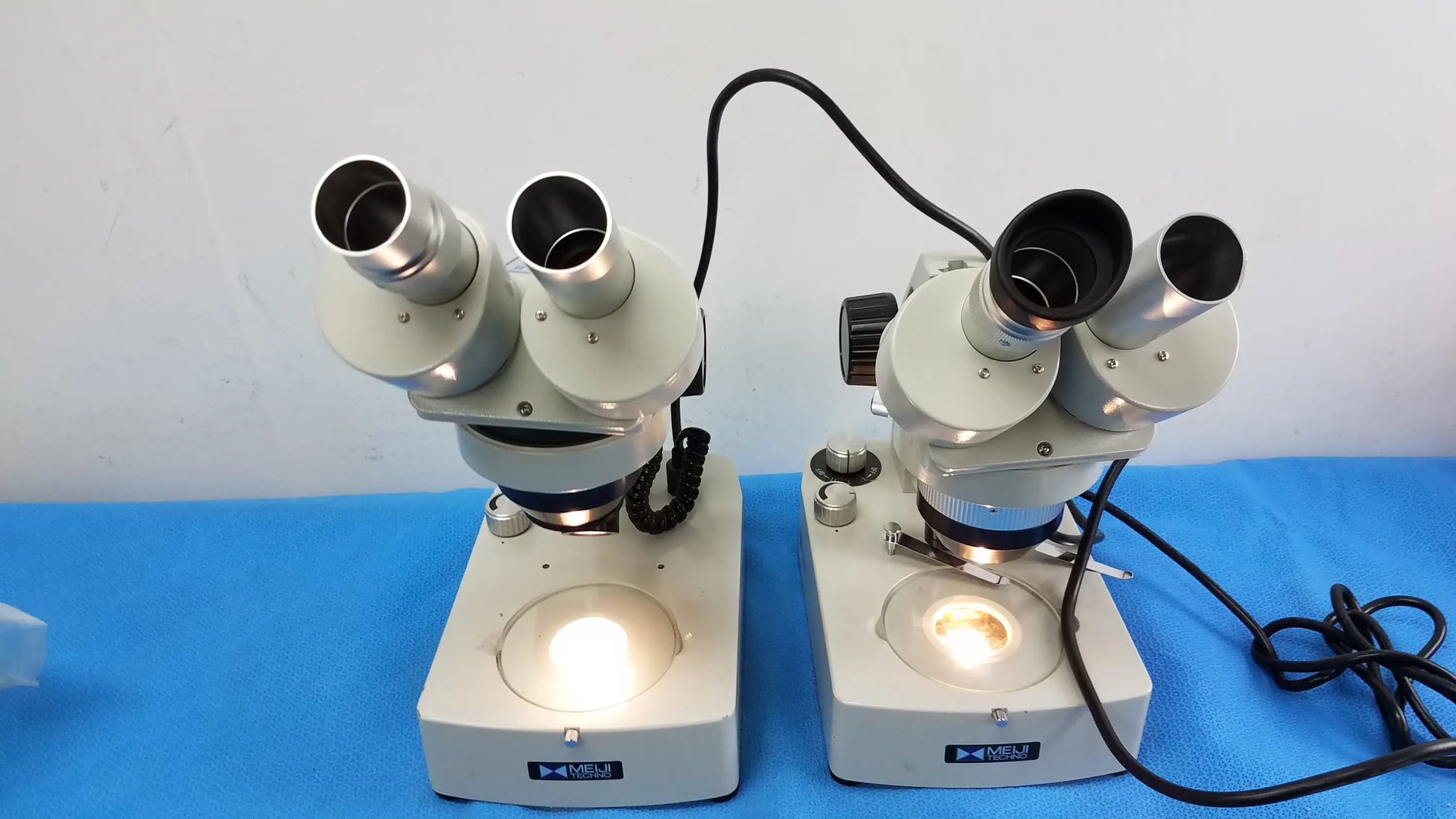 Lot of 2 meiji techno emt-1 stereo microscope medical equipment with dual eyepieces white and silver compound design