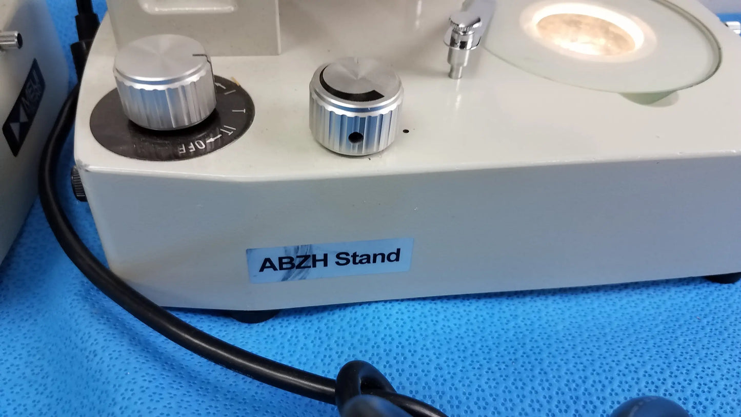 White meiji techno EMT-1 stereo microscope with silver metallic knobs and circular illuminated light source medical equipment