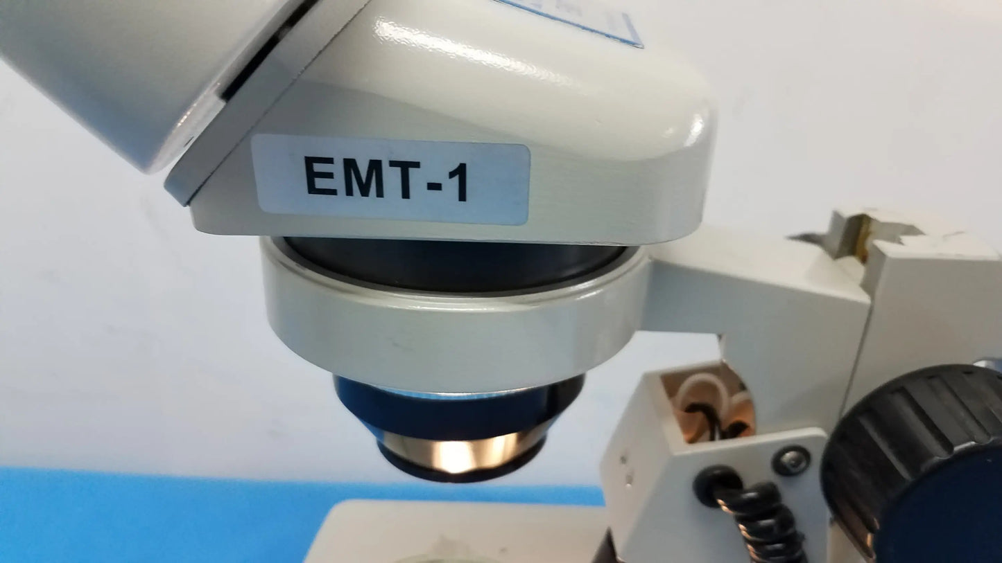 White meiji techno emt-1 stereo microscope with blue and gold lens assembly for medical equipment use
