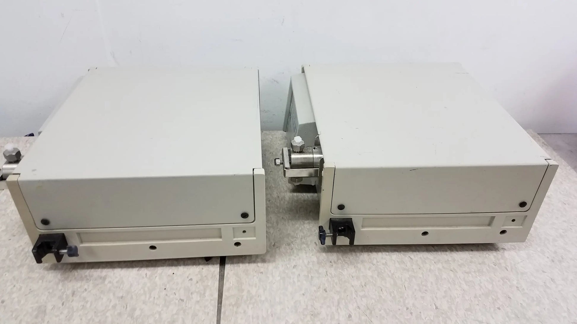 Two beige rectangular industrial enclosures with metallic connectors and black knobs for buy used medical equipment
