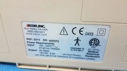 Beige plastic medical equipment showing the back side of a duet portable aspirator with a white specification label