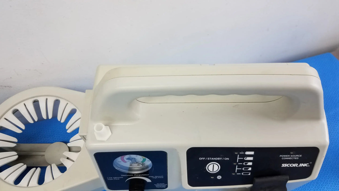 White plastic duet portable aspirator with blue circular component and control panel by scor inc medical equipment