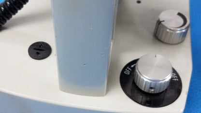 Light blue stereo microscope with silver adjustment knobs and black base for inverted binocular microscope use