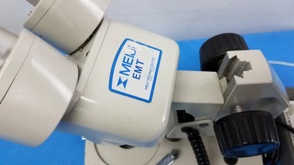 White plastic stereo microscope with blue and black accents labeled melui emt in a lot including inverted binocular microscope