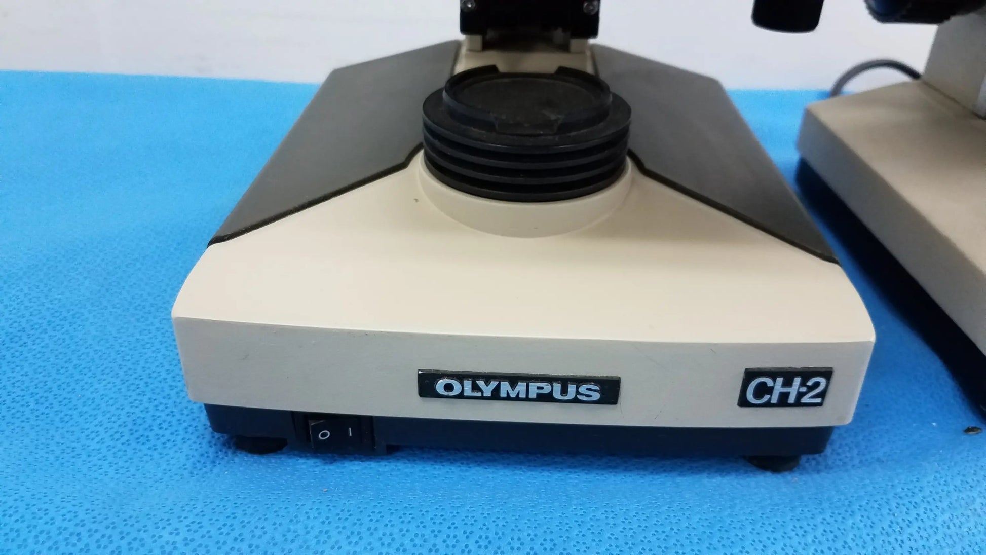 Beige and black olympus ch2 microscope base with matte finish for reuse medical equipment in laboratory settings