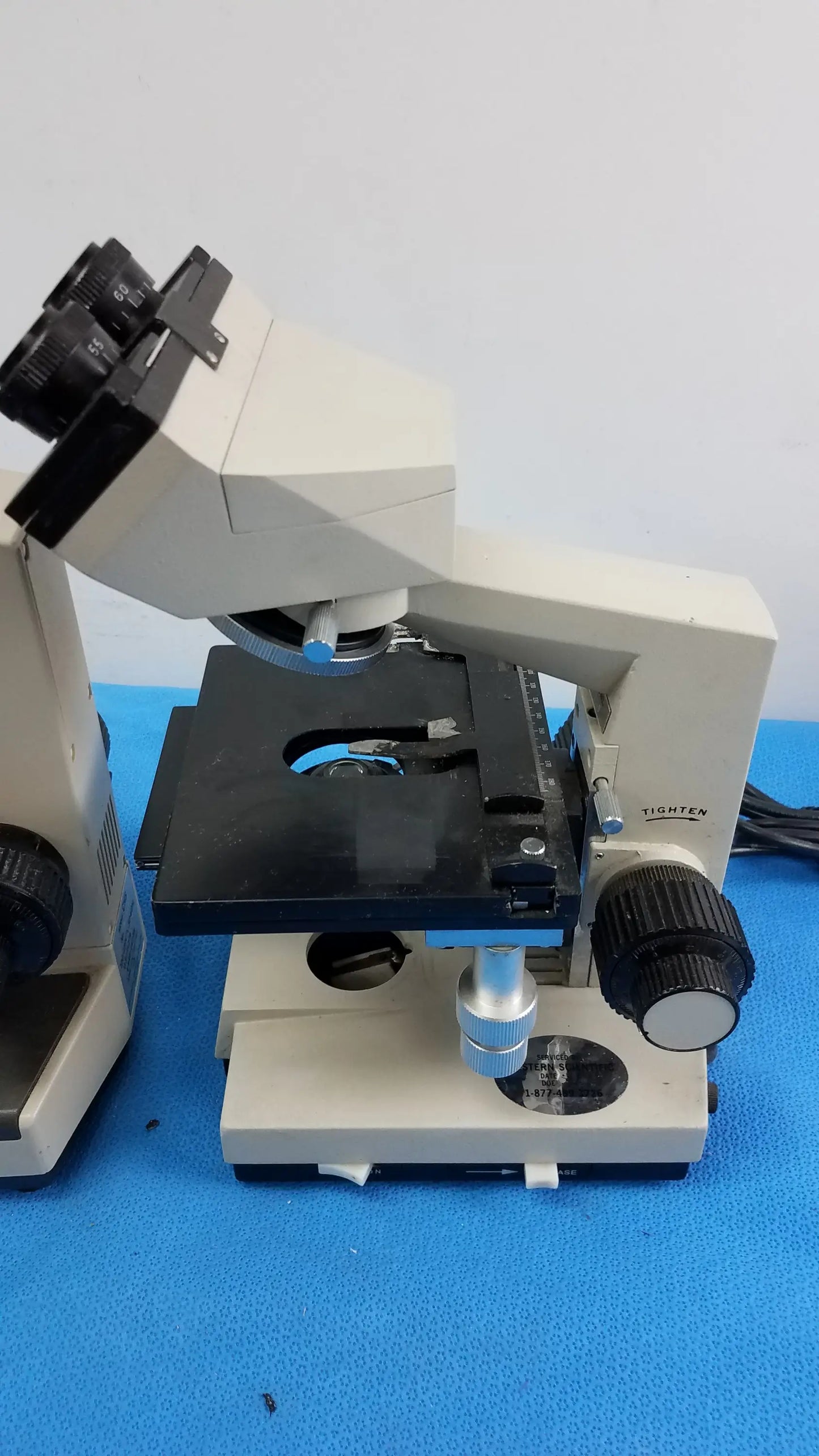Beige and black Wesco and Olymus CH-2 laboratory microscopes with dual eyepieces and adjustable focus for reuse medical equipment