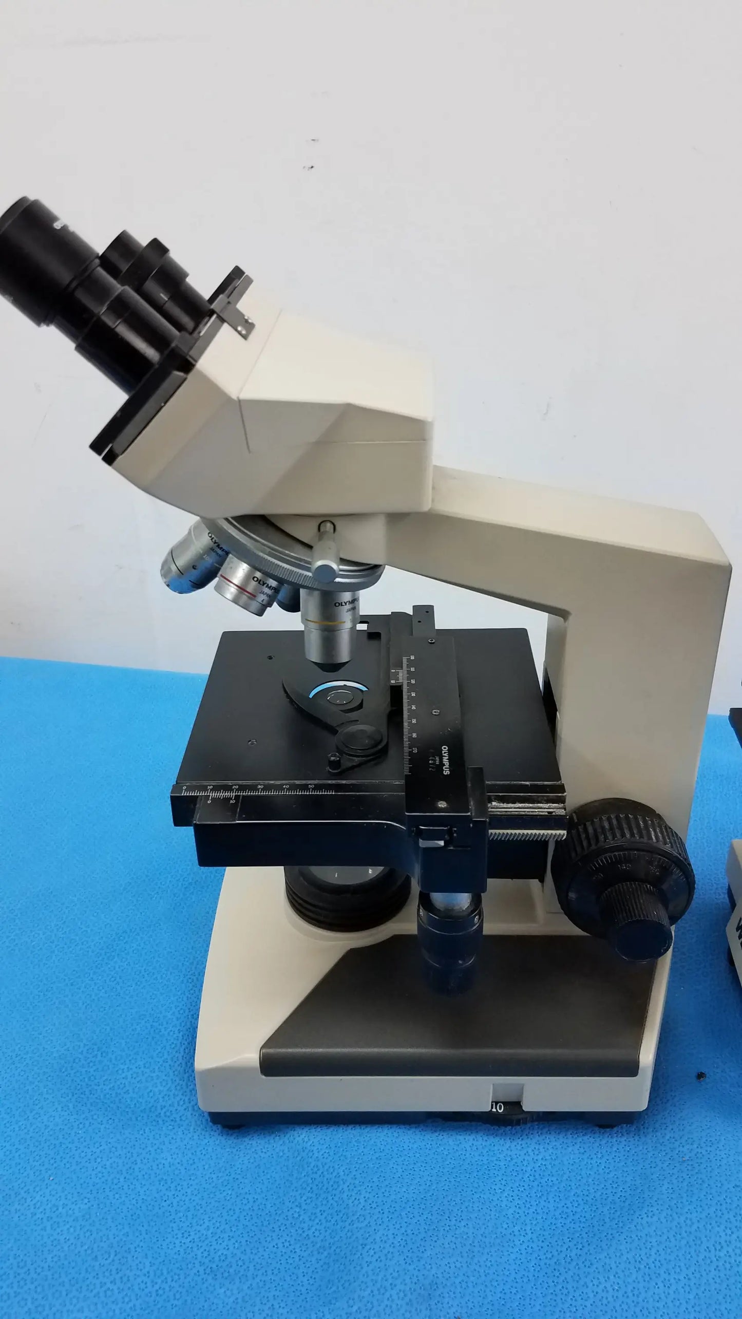 Beige and black wesco and olymus ch-2 laboratory microscopes with adjustable stage for reuse medical equipment purposes