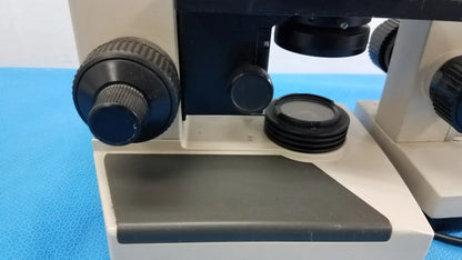 Black and white wesco and olymus ch 2 compound microscopes with textured knobs and stage for reuse medical equipment