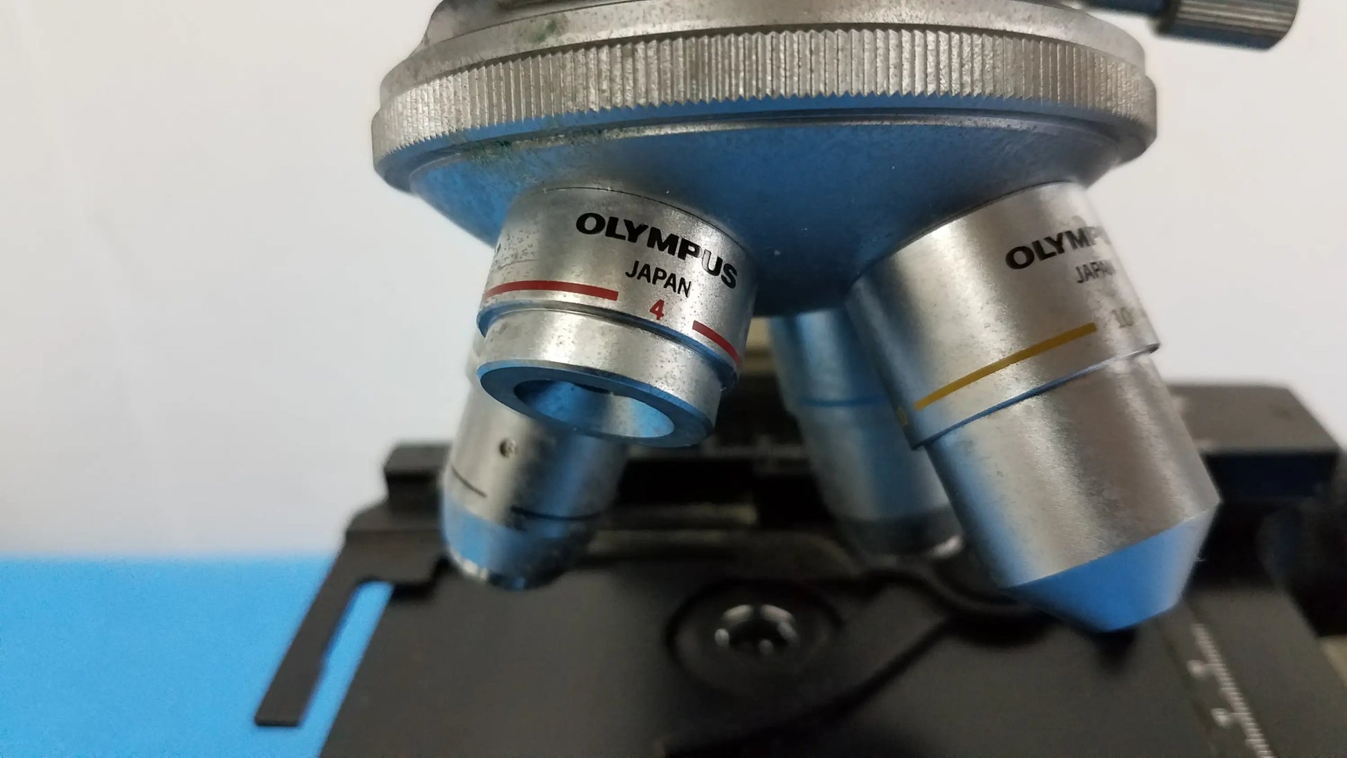 Silver Olympus microscope objective lenses with blue accents and Japan engraving for reuse medical laboratory equipment