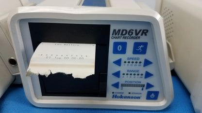 White plastic hokanson md6vr chart recorder with blue buttons and low battery paper strip in output slot medical equipment