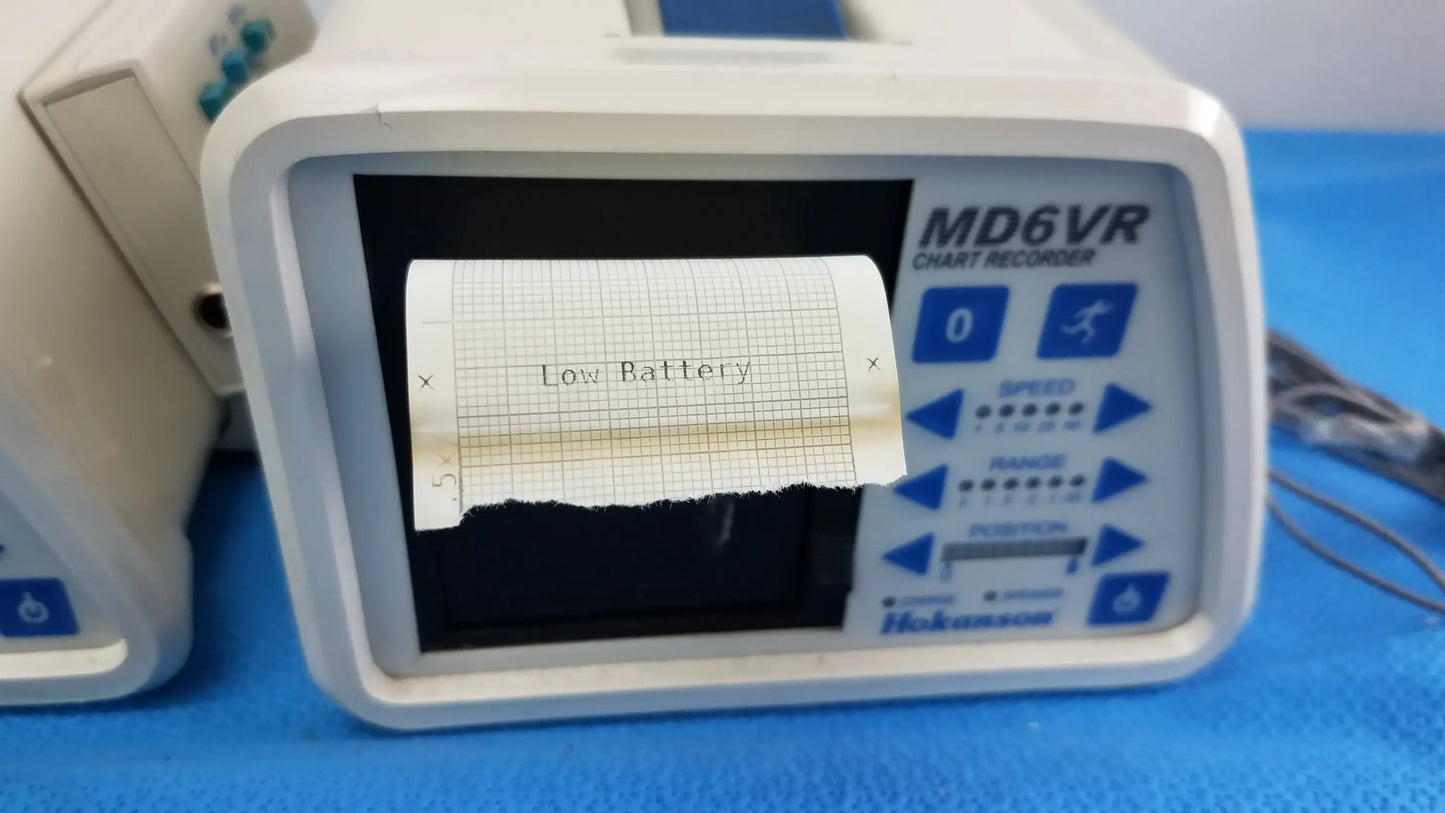 White plastic hokanson md6vr chart recorder with blue labeling and low battery message on printed paper strip medical equipment