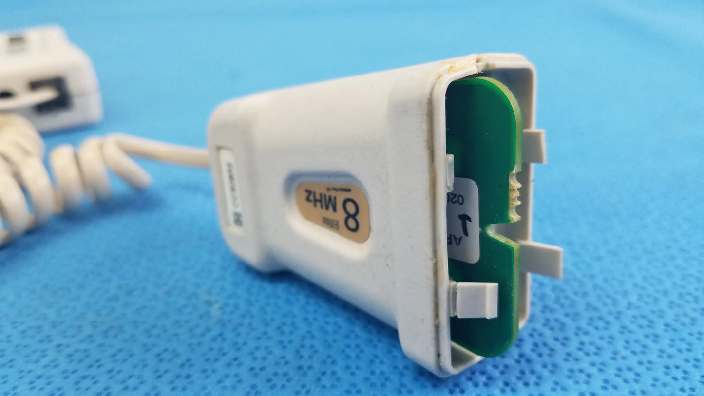 White plastic handheld doppler with green circuit board labeled 8 mhz for reuse medical equipment natus neurology elite