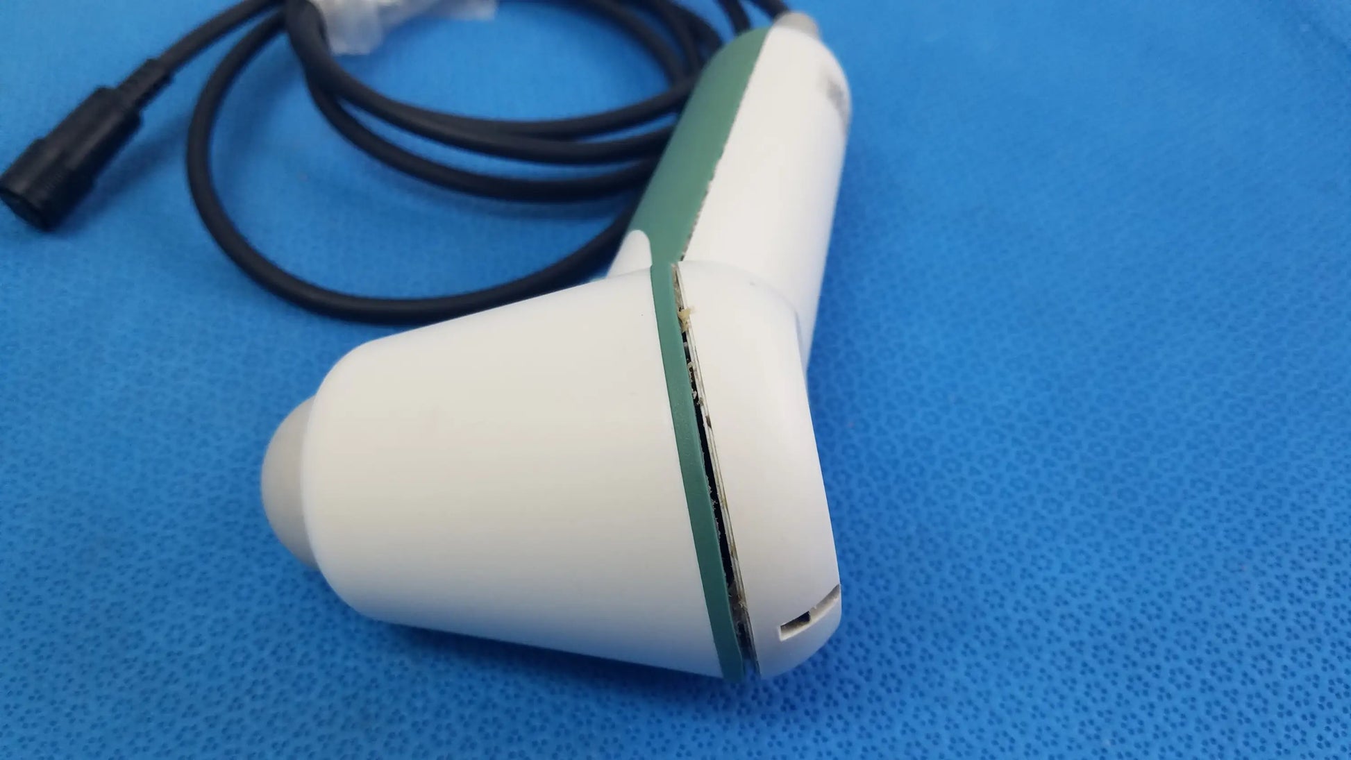 White and green handheld verathon bladderscan ultrasound probe with black cable for reuse medical equipment