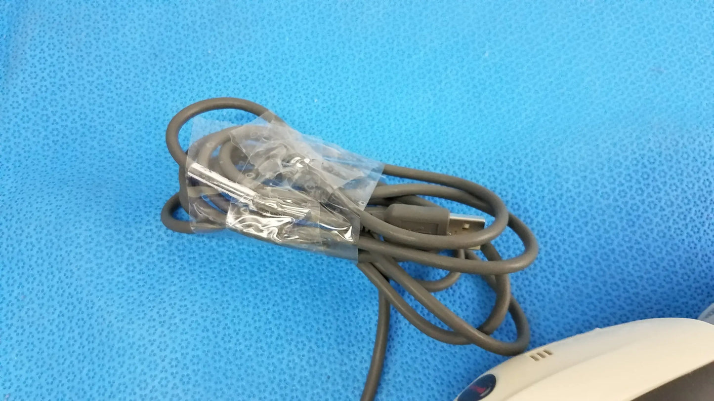 A coiled gray usb cable wrapped in clear plastic for a lot of 4 laser barcode scanner readers used in medical equipment