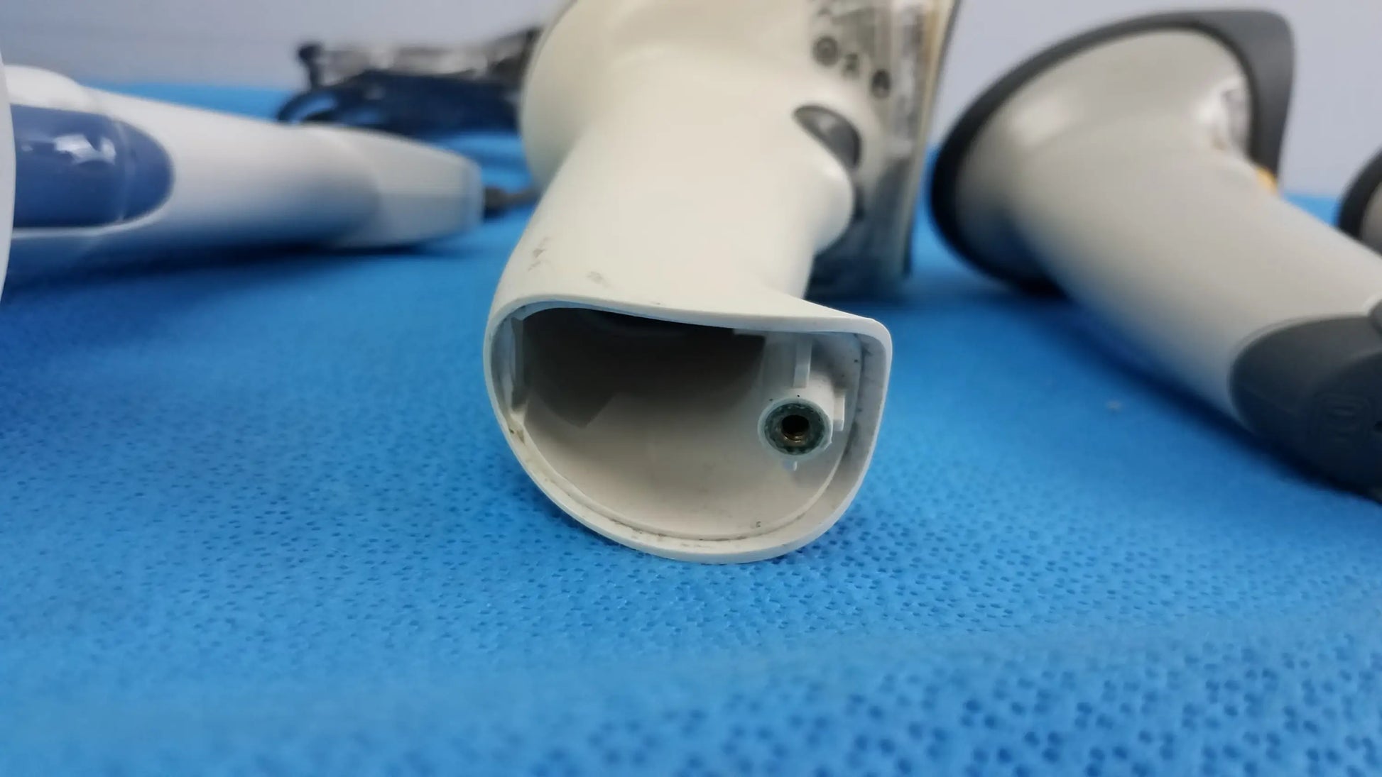Off-white laser barcode scanner with rounded grip and black lens in lot of 4 for reuse medical equipment applications