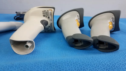 Lot of 4 laser barcode scanner readers featuring three white and gray handheld scanners with black grips and a yellow trigger button for reuse medical equipment