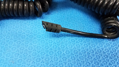 Black coiled cord with frayed connector end for wall transformer ideal for reuse medical equipment assemblies