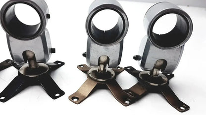 Three identical metallic metal clamps with cylindrical tops and four-legged bases for hospital surplus equipment use