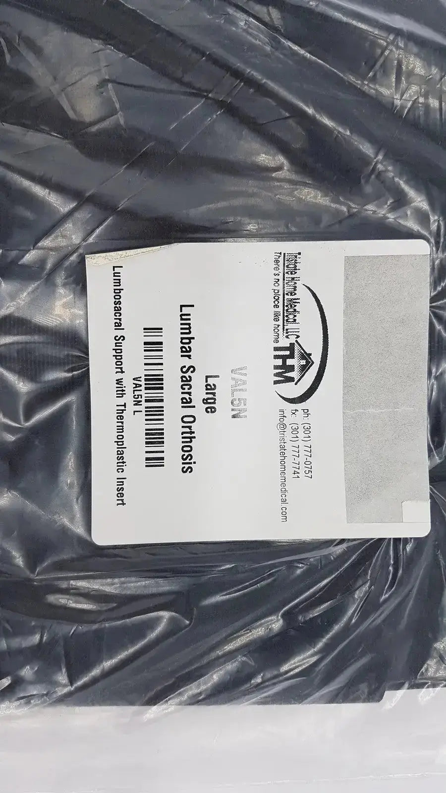 Black plastic-wrapped sacral orthosis val5n with white label featuring product details and branding large lumbosacral support