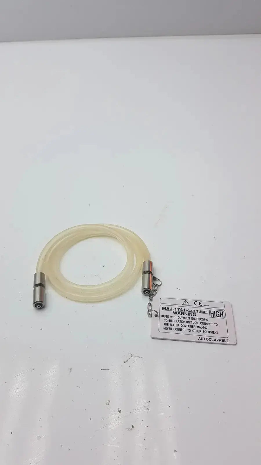 Clear flexible high-flow gas tube with metallic connectors and warning label for Olympus endoscopic gas tube fit unit