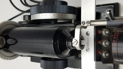 Black cylindrical microscope stage with silver metallic parts and engraved markings on marco model 101 manual lensmeter hospital surplus
