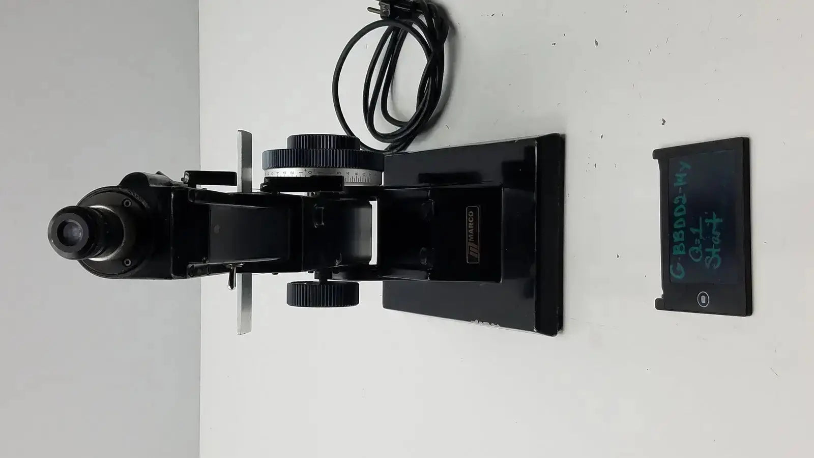 Black metal marco model 101 manual lensmeter with adjustable stage and objective lens for hospital surplus use