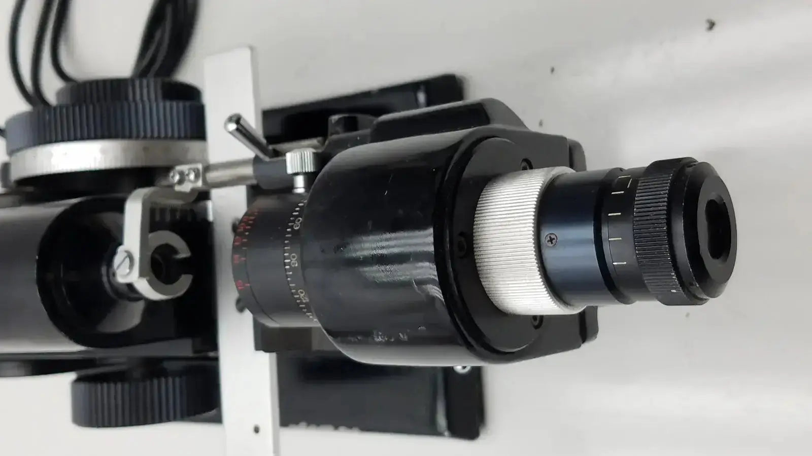 Black and silver microscope objective lens with knurled adjustment rings for marco model 101 manual lensmeter hospital surplus