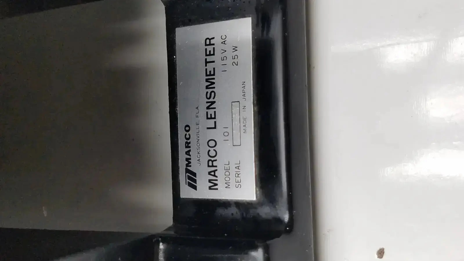 Black marco model 101 manual lensmeter with white label displaying model and specifications hospital surplus device