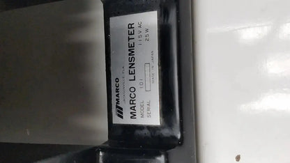 Black marco model 101 manual lensmeter with white label displaying model and specifications hospital surplus device
