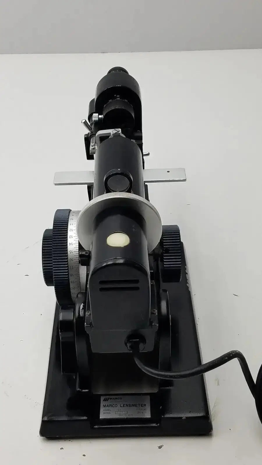 Black metal marco model 101 manual lensmeter with silver-rimmed dial and adjustable lenses for hospital surplus use