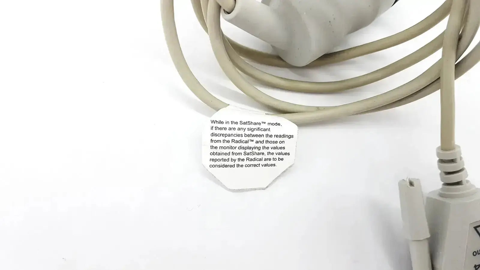 Beige coiled masimo d006 satshare interface cable with white label showing instructional text for medical use