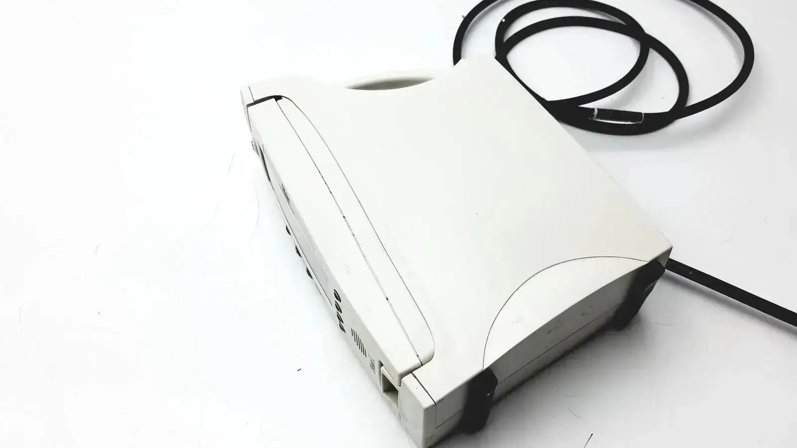 White plastic laptop with black cable coiled beside it in masimo signal extraction pulse oximeter setup