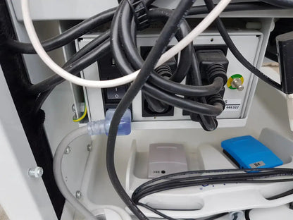 White plastic power outlet panel with black and white cables plugged in on the back of mauna kea technologies cellvizio f-400 v2 manometry system