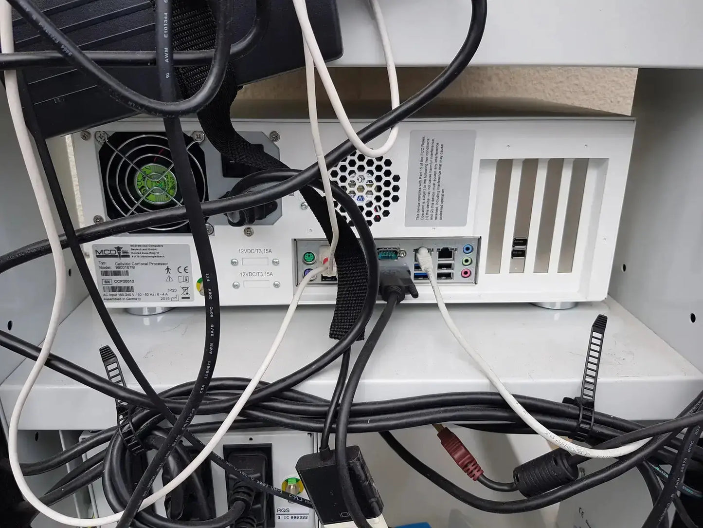 White computer tower with black cables and green fan on left side of mauna kea technologies cellvizio f-400 v2 manometry system