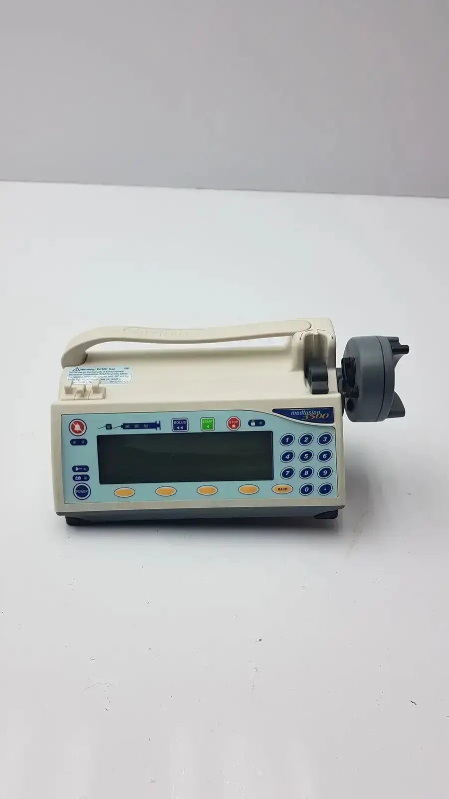 Beige medfusion 3500 infusion pump with digital display, blue and yellow buttons, gray motor housing, and pole clamp for biomedical evaluation in hospital surplus