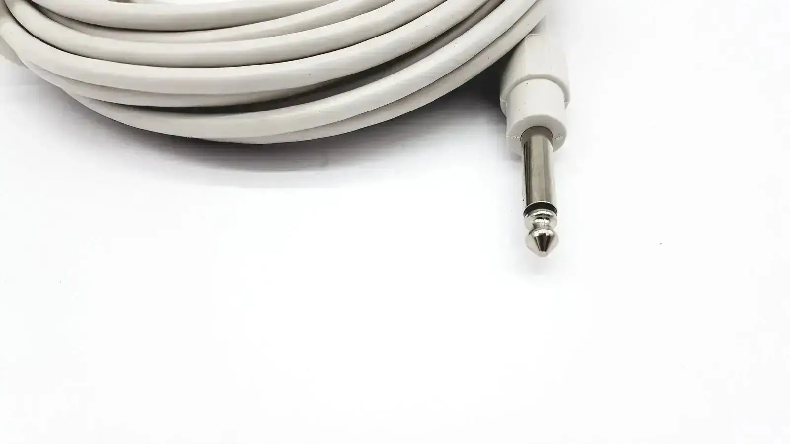 A coiled white ibp cable with reusable bare copper wire and a metallic 6.35mm jack for mindray medical use