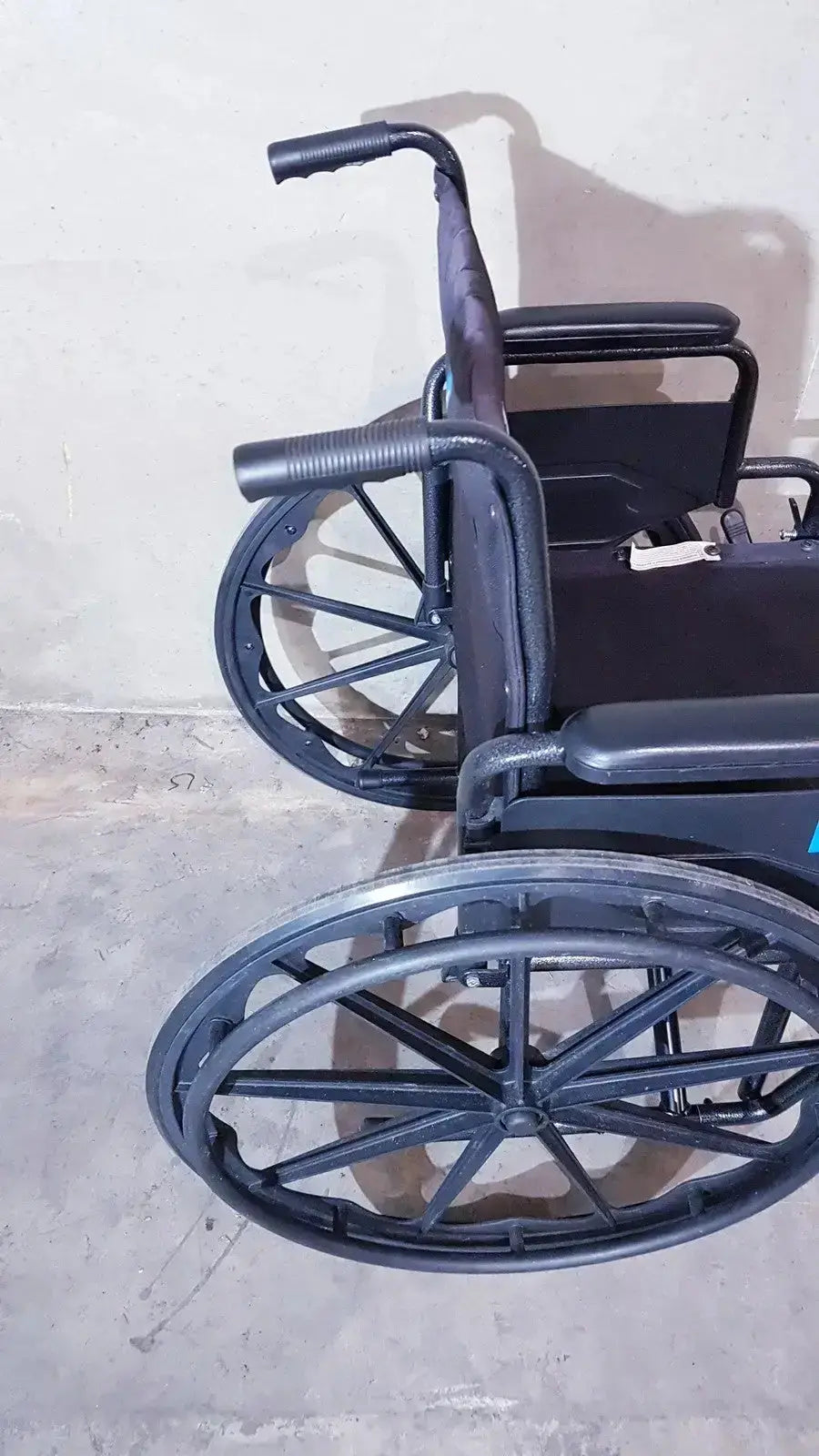 Black medline guardian k1 lightweight wheelchair compact seat with textured grip handles and spoked wheels shown from back