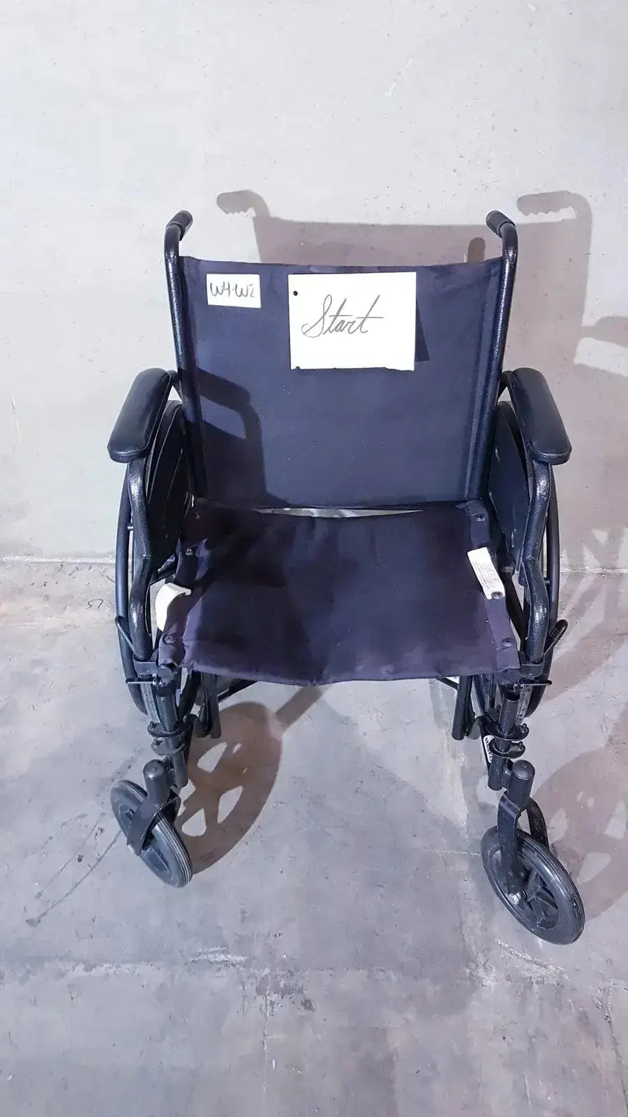 Black metal guardian k1 lightweight wheelchair with dark blue fabric compact seat and handwritten note on backrest