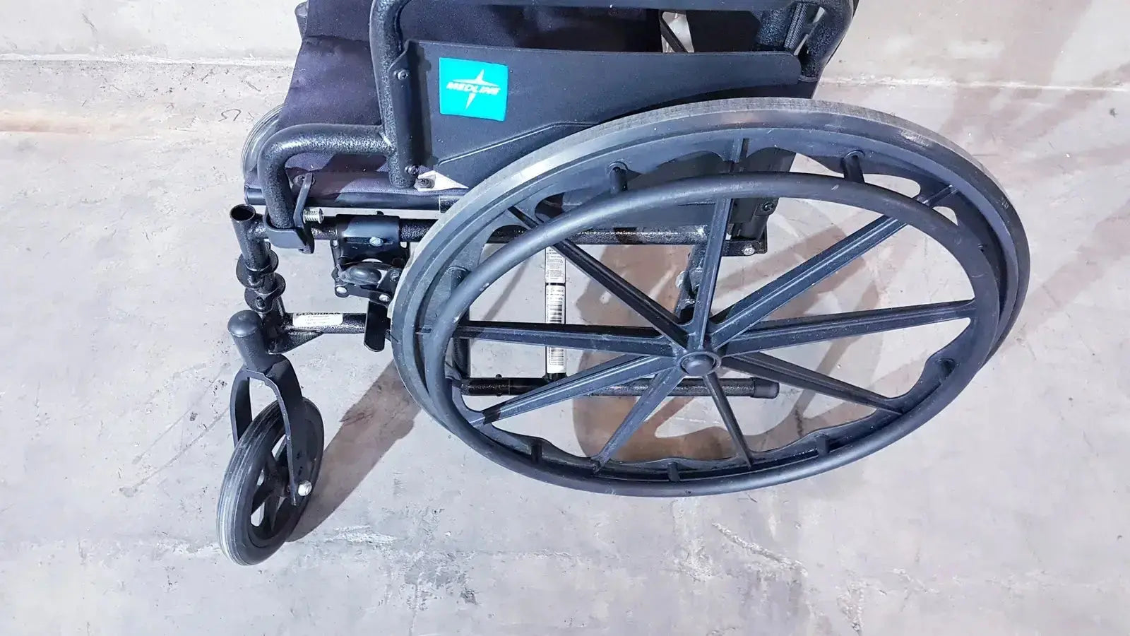 Black guardian k1 lightweight wheelchair compact seat rear view with large wheels and teal logo on backrest